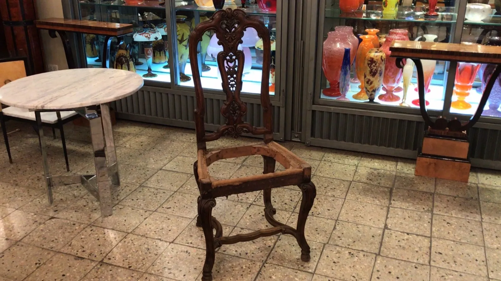 Une chaise ancienne dans un cadre d'antiquités, entourée d'objets décoratifs colorés