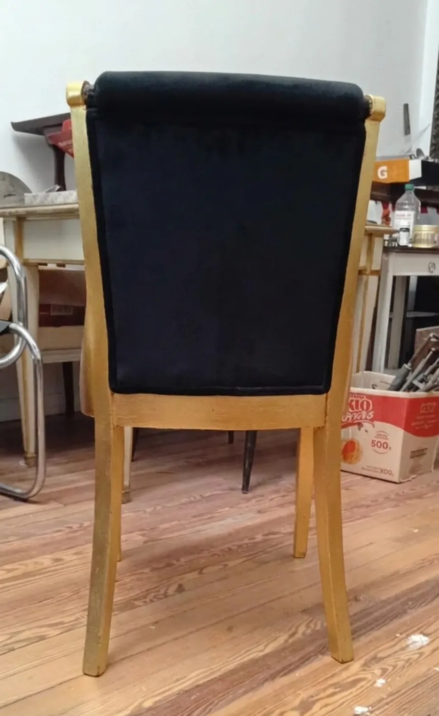 Vista posteriore di 6 sedie antiche con tessuto nero, ambiente di restauro.