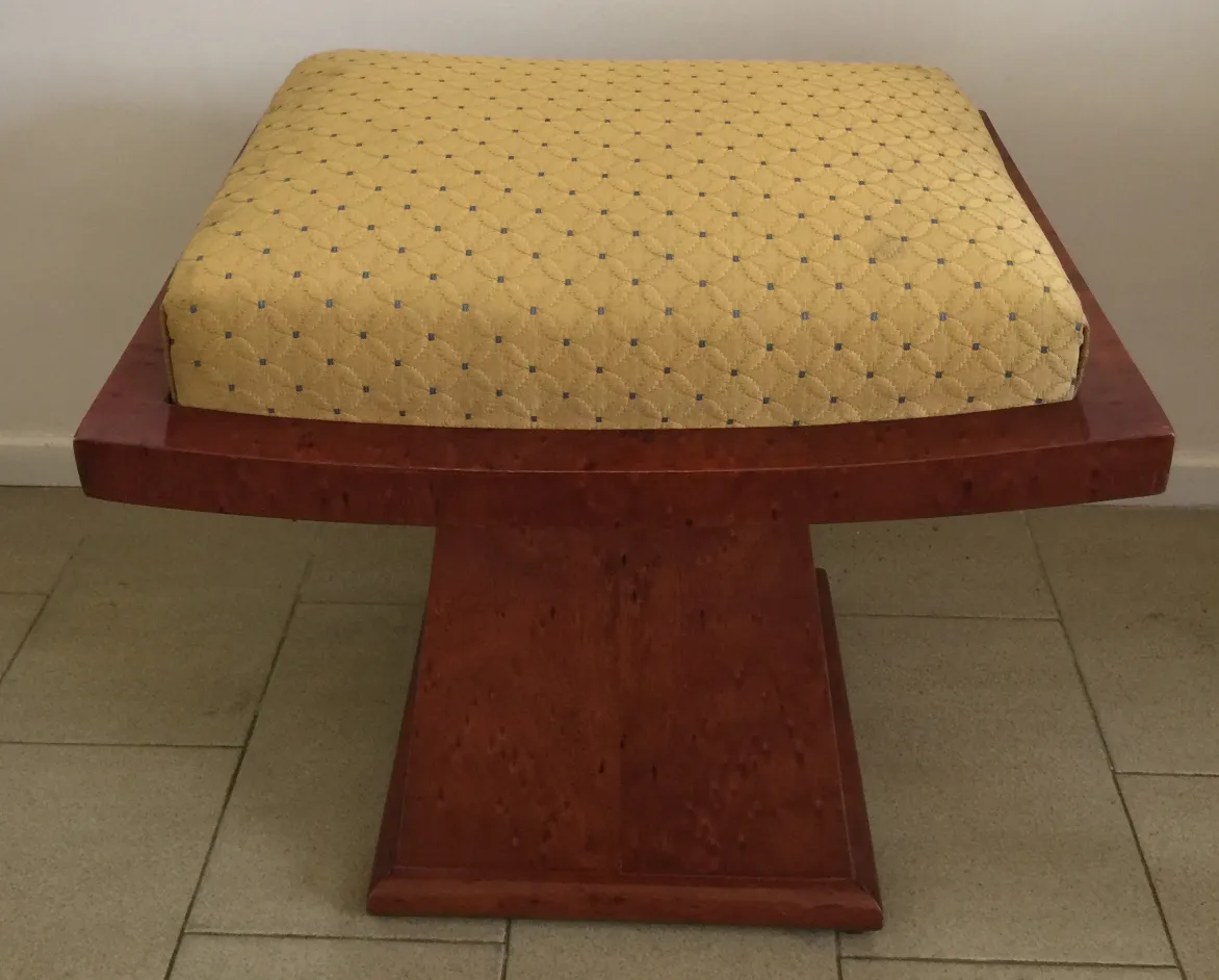 Sgabello antico con cuscino giallo e design elegante.