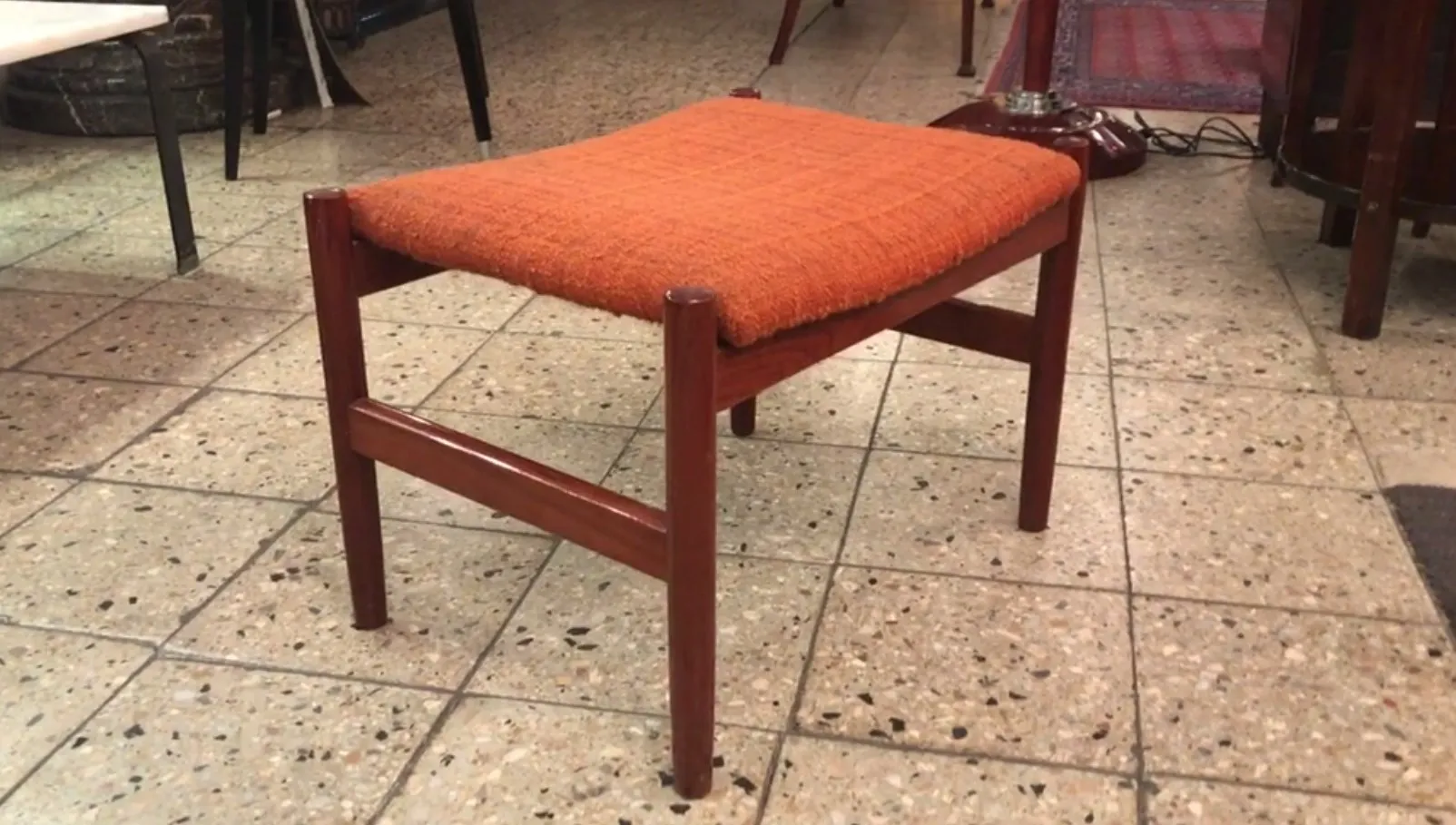 sgabello classico con cuscino arancione in un ambiente accogliente