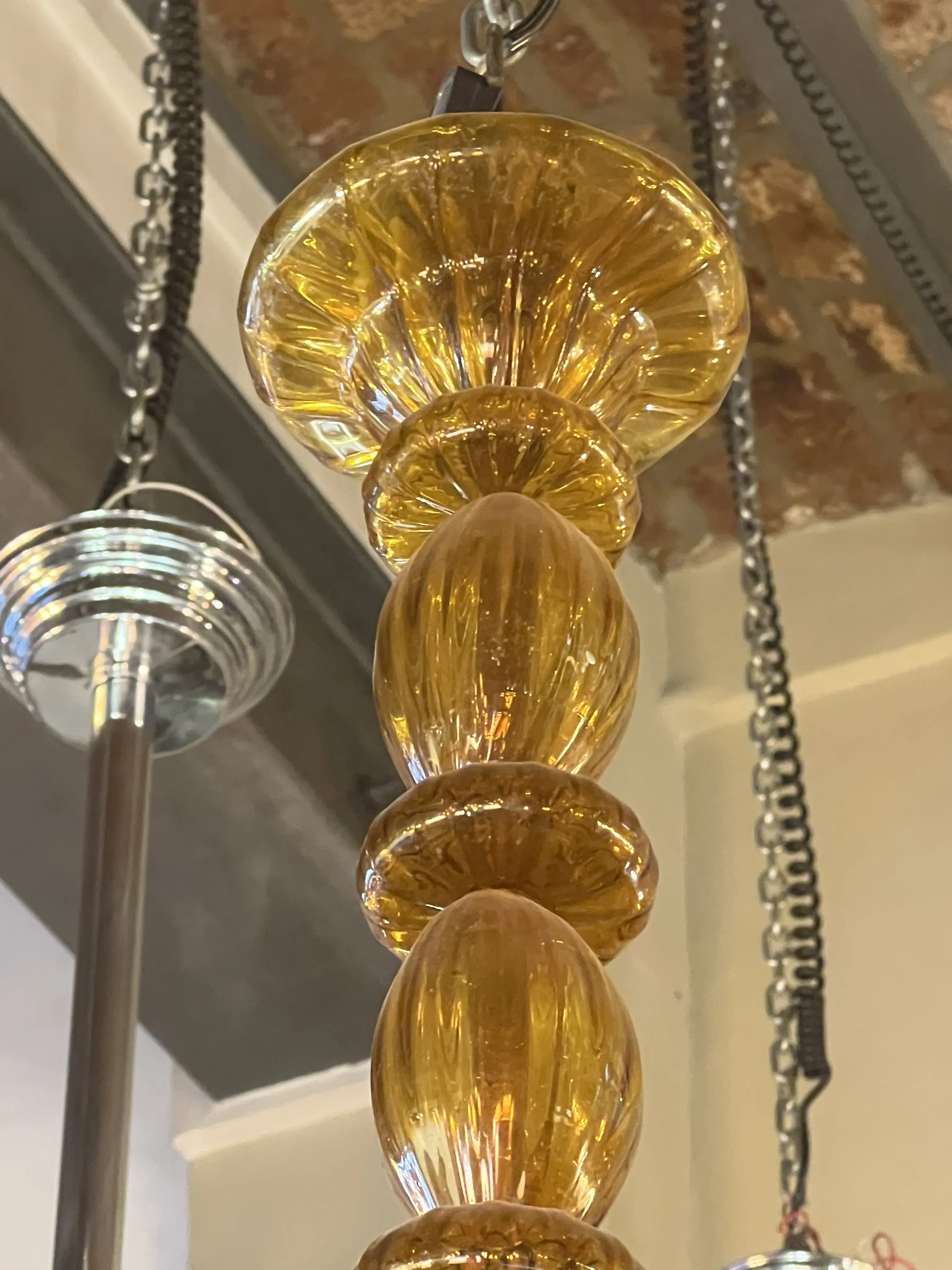 Antiga lampada de teto com design de vidro amarelo brilhante, iluminando um ambiente acolhedor.