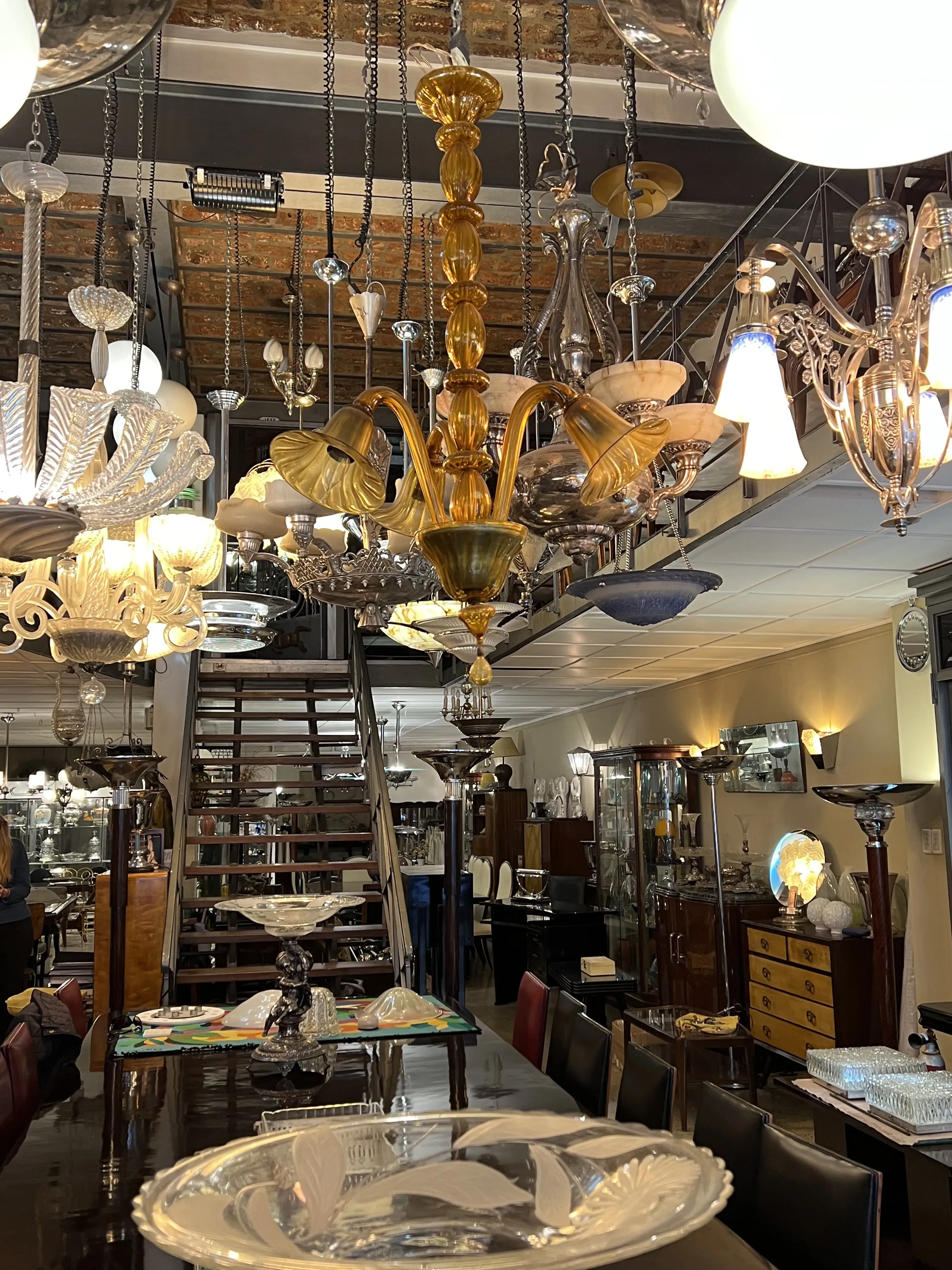 ancienne lampe à suspension avec lumières brillantes dans une boutique d'antiquités, entourée d'autres objets décoratifs