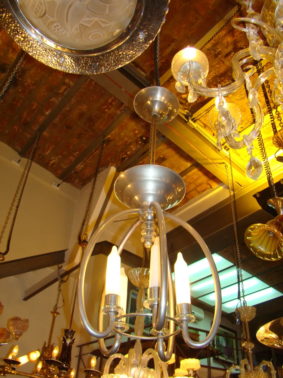 Lampada a sospensione antica in stile art deco con candele accese, atmosfera calda.