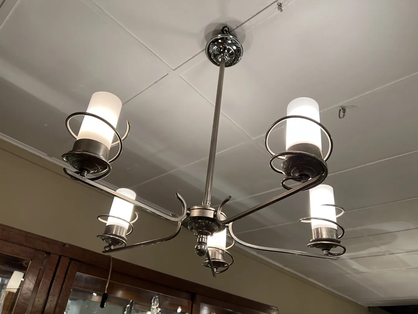 Lámpara de techo antigua estilo art deco con luces brillantes en un ambiente acogedor.