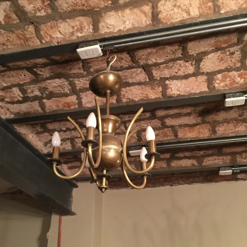 Vintage hanging lamp in Art Deco style with 5 arms, set in a brick exposed environment