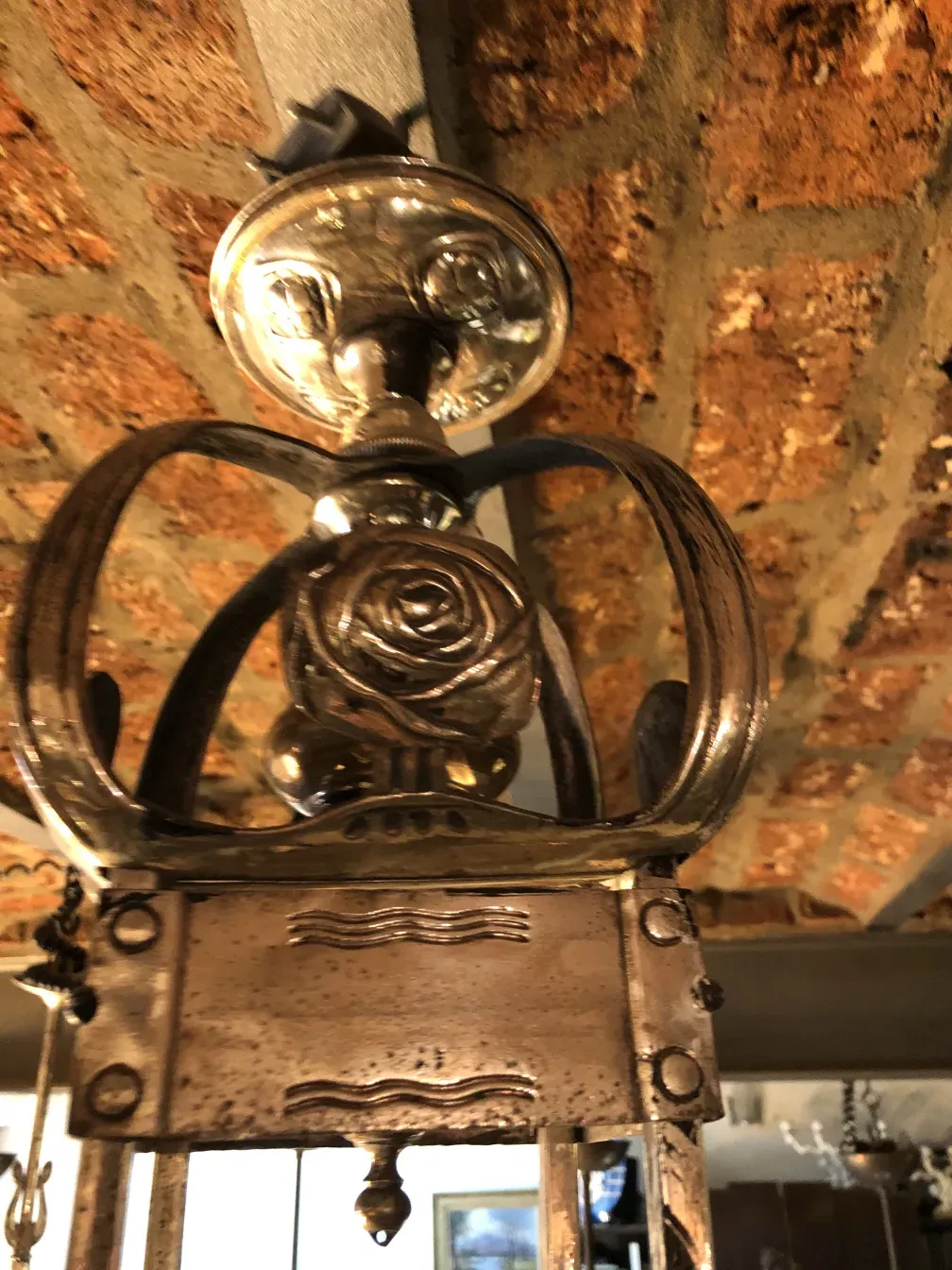 Lâmpada de teto antiga com detalhes florais em um ambiente vintage.