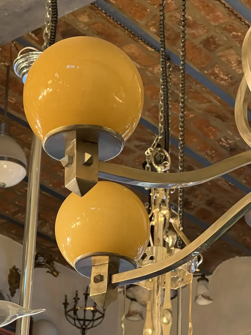Lustre ancien art déco avec globes jaunes, illuminant élégamment l'espace.