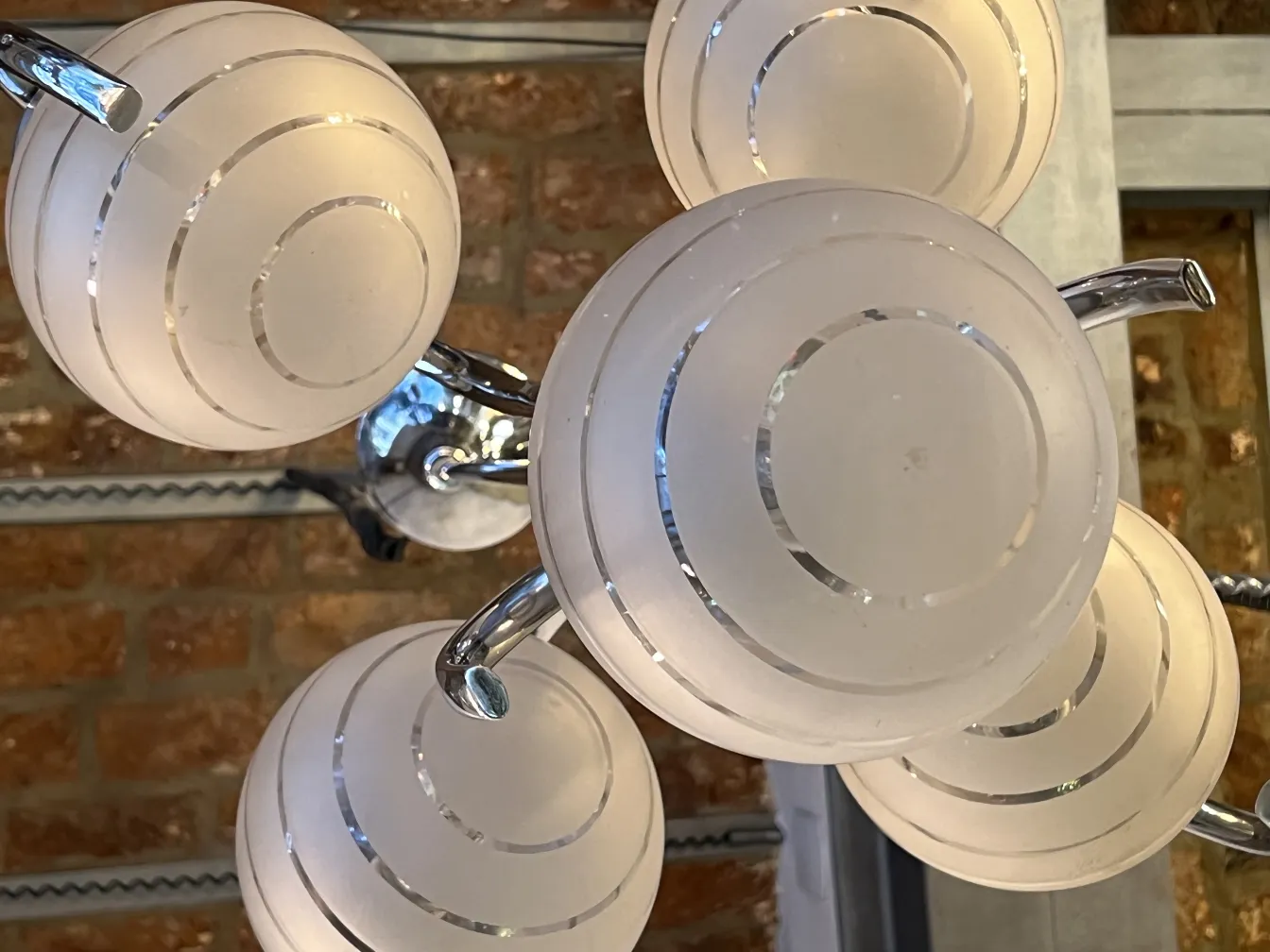 Lampada a sospensione antica con sfere in vetro sabbiato, atmosfera accogliente.