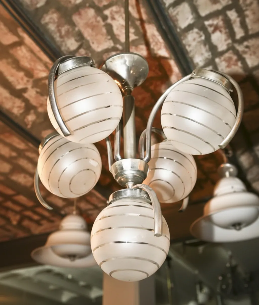 lampada a sospensione antica con globi di vetro bianco in un ambiente accogliente