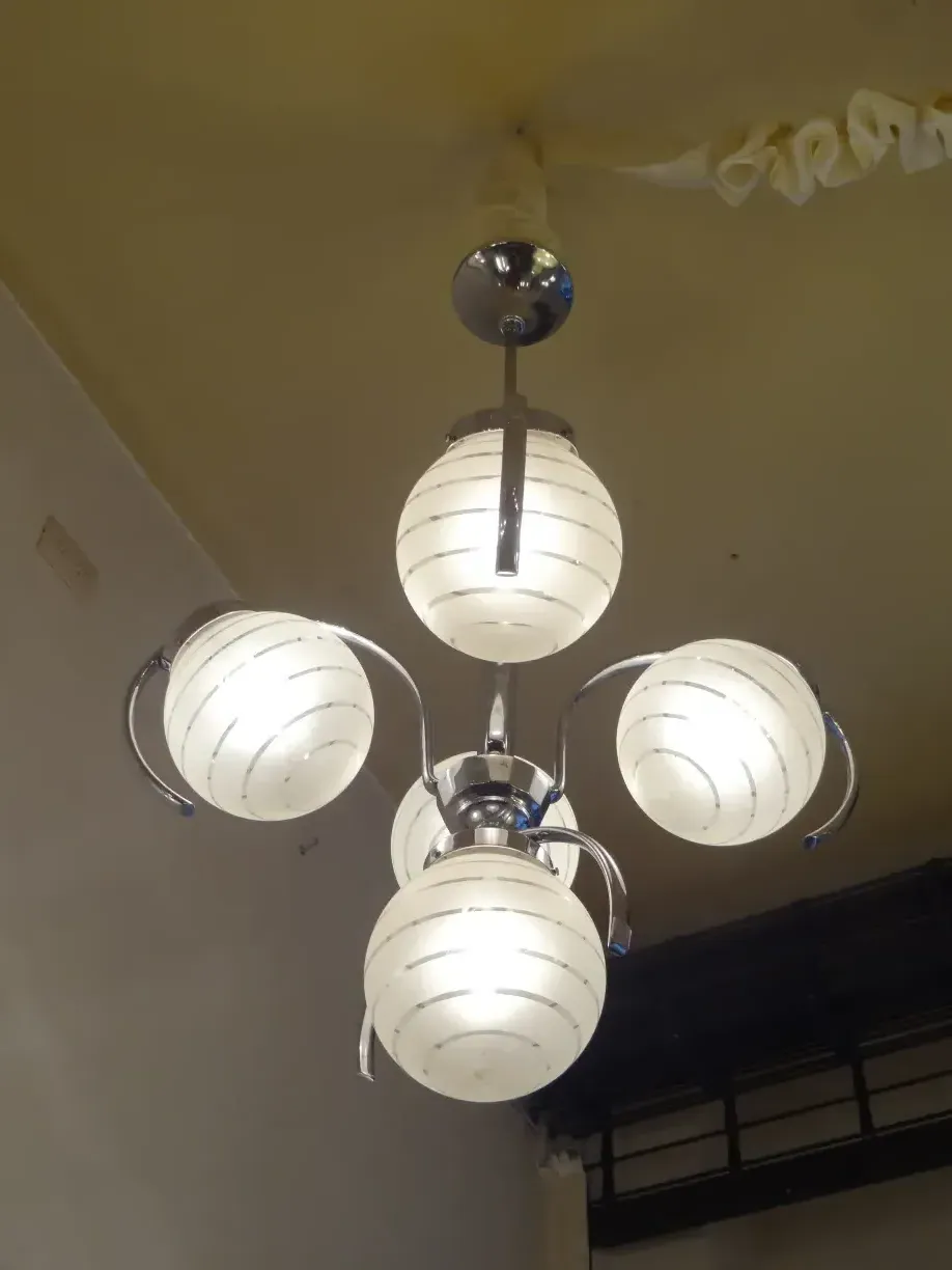 lâmpada de teto antiga com três luzes esféricas em ambiente estilizado