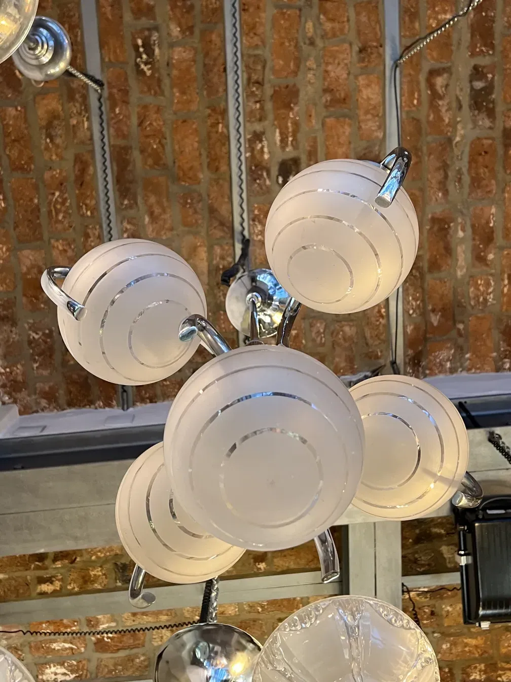 Старинная подвесная лампа арт-деко с белыми сферами на индустриальном фоне. Кирпичная стена.