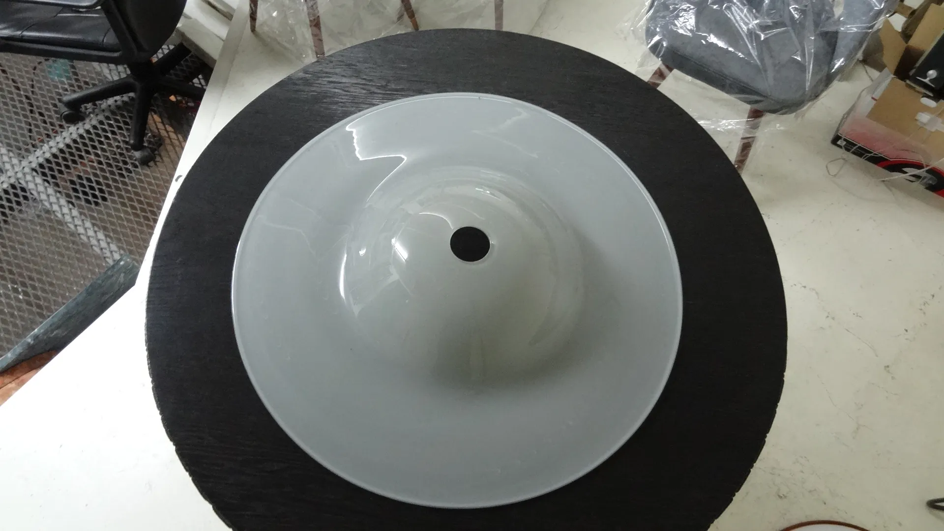 Una lámpara de techo antigua con diseño simple y elegante, en un ambiente acogedor con una mesa oscura.