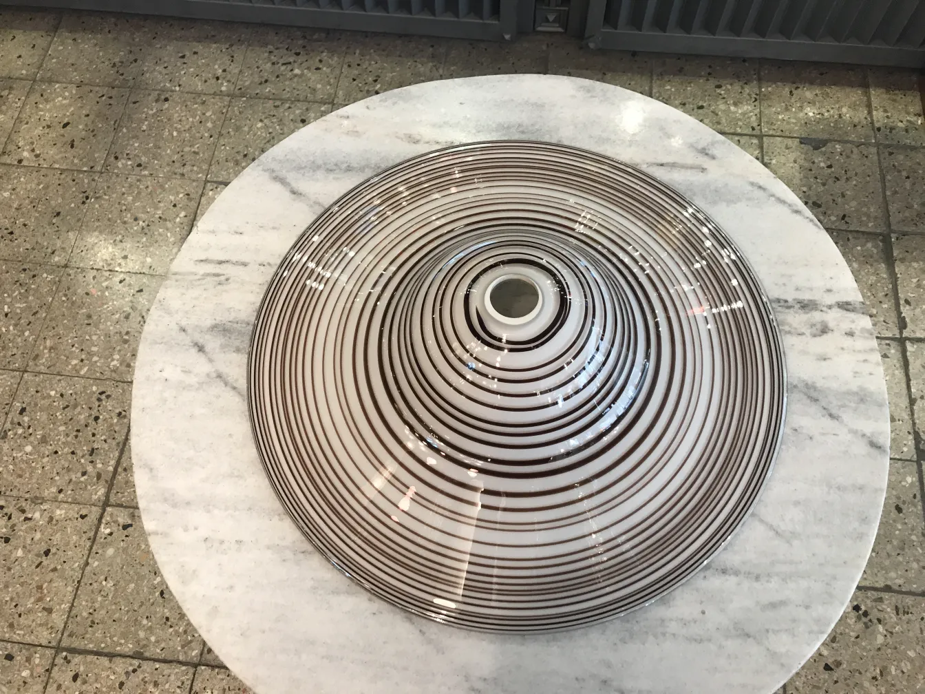 lâmpada de teto antiga com designs circulares sobre uma mesa branca