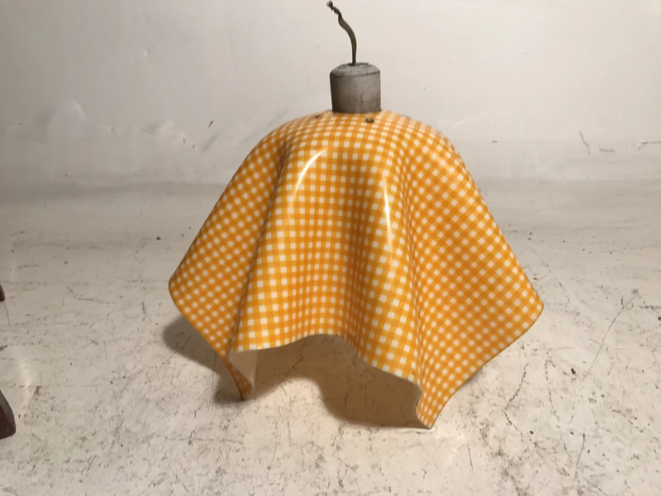 Lampada a sospensione antica con design colorato in un ambiente neutro.