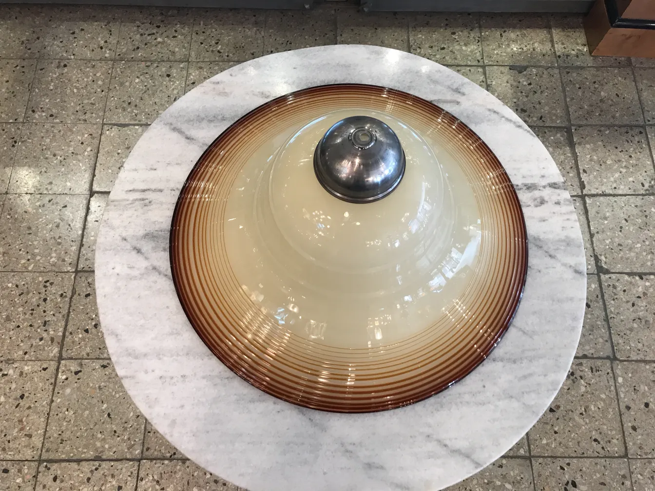 Antiga lâmpada de teto com design clássico e detalhes circulares, cercada por um ambiente acolhedor.