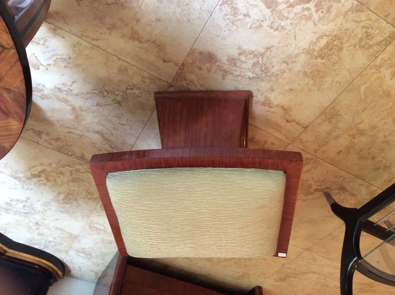 Antique stool with a soft seat in a cozy setting.