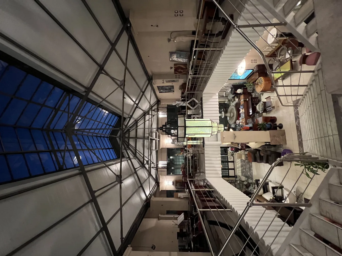 Antike Glaslampe in einem hellen Raum, umgeben von Möbeln und Dekoration.