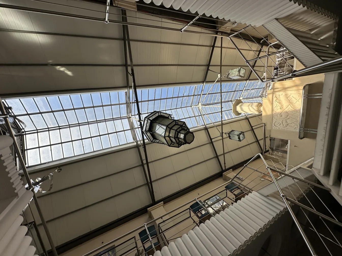 Античный фонарь, висящий в современном пространстве при естественном освещении.