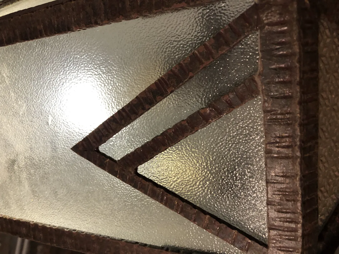 Antique lantern featuring textured glass and dark frame.