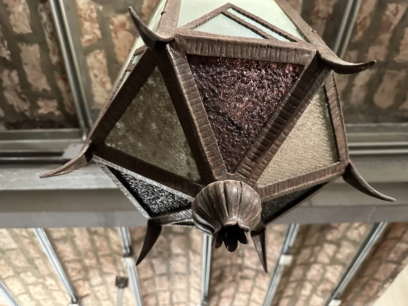 Farol antiguo de vidrio con detalles decorativos.