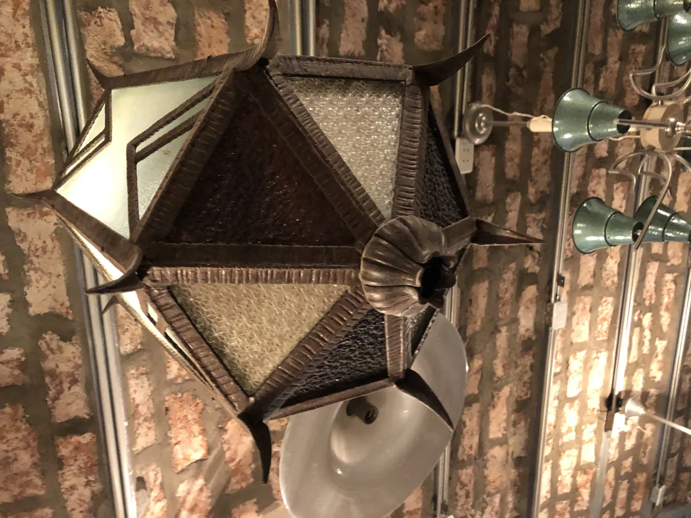 Antique faceted lantern hanging from a ceiling.