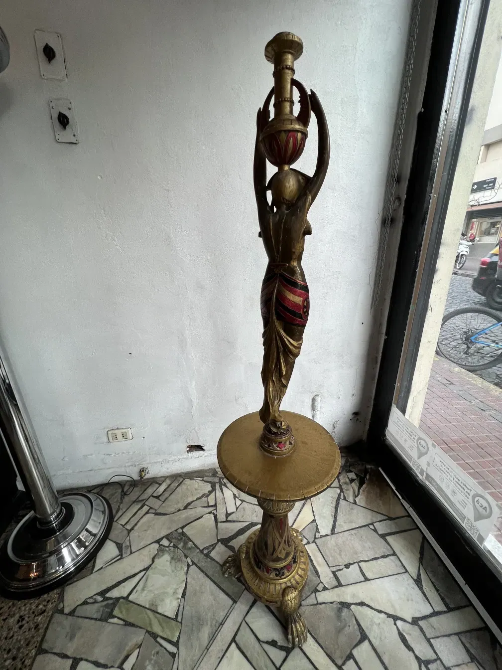 scultura in piedi con dettagli dorati e decorativi