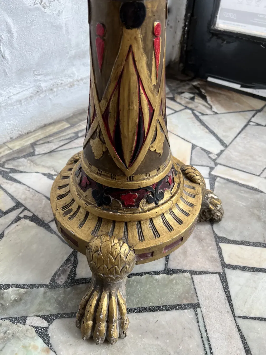 Scultura antica con dettagli ornamentali scolpiti nella base.