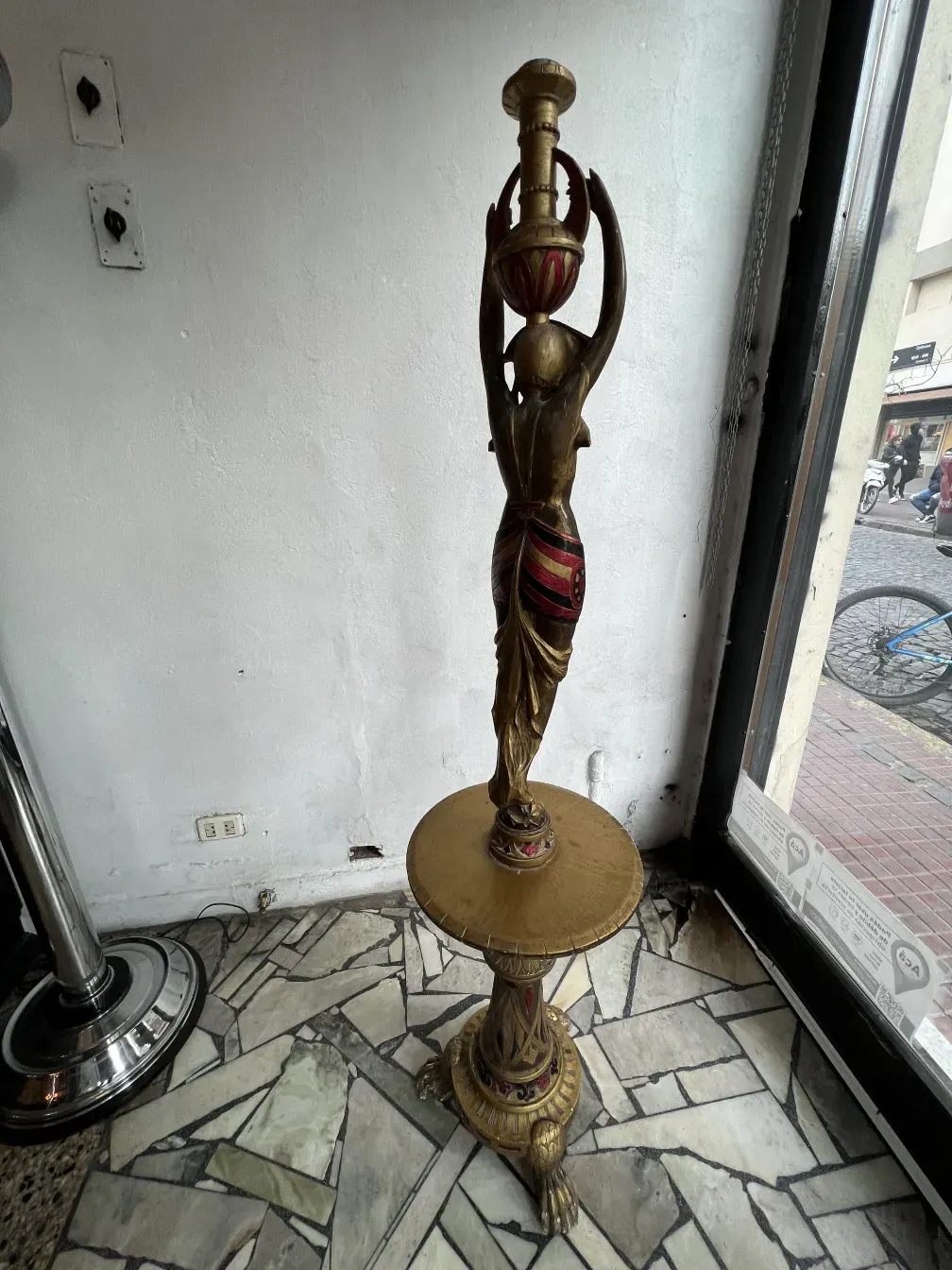 Escultura antiga de bronze com detalhes vermelhos, elegante e distinta.