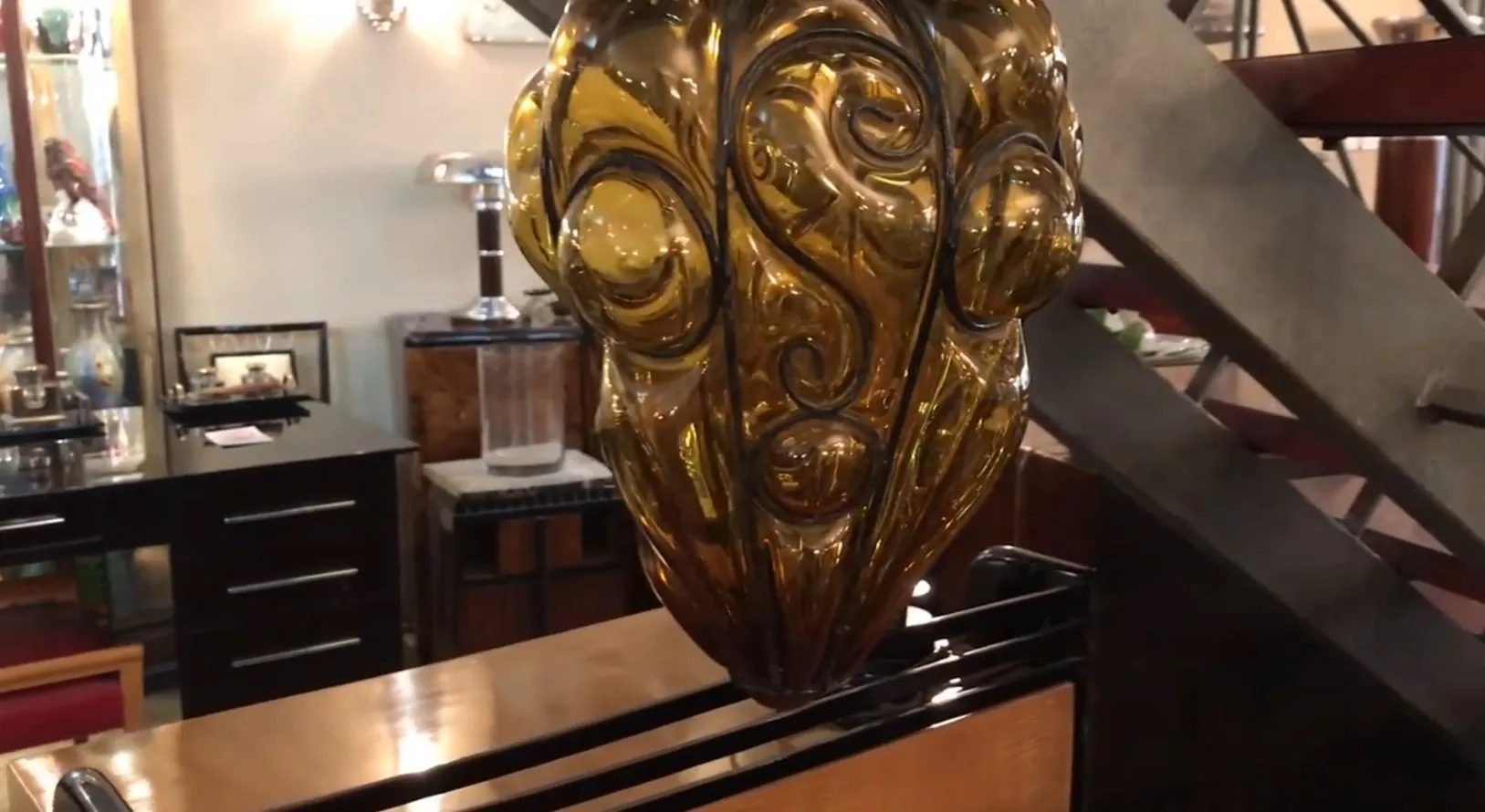 Lanterna antica in vetro ambra con design decorativo in un ambiente vintage.