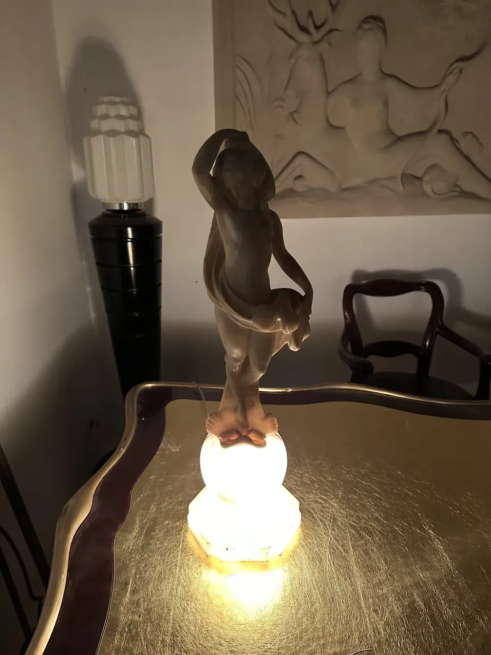 Antique decorative sculpture of a female figure in an elegant setting