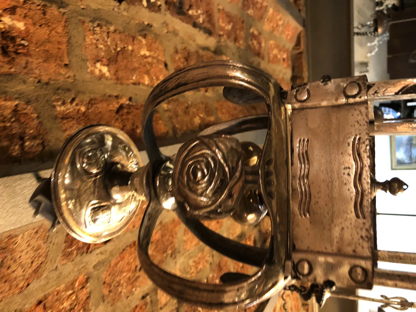 antique lantern with rose embellishments on a brick wall