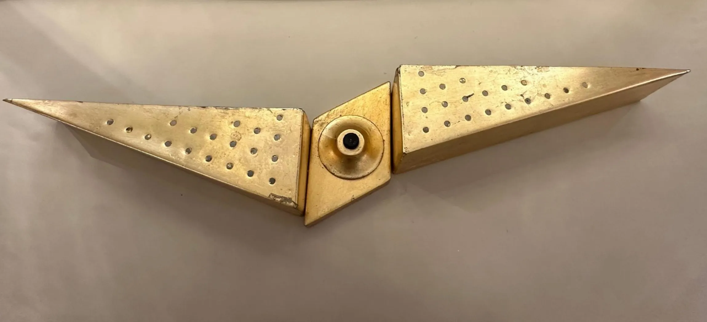 Applique ancien de 1950 avec un design symétrique et des trous décoratifs.