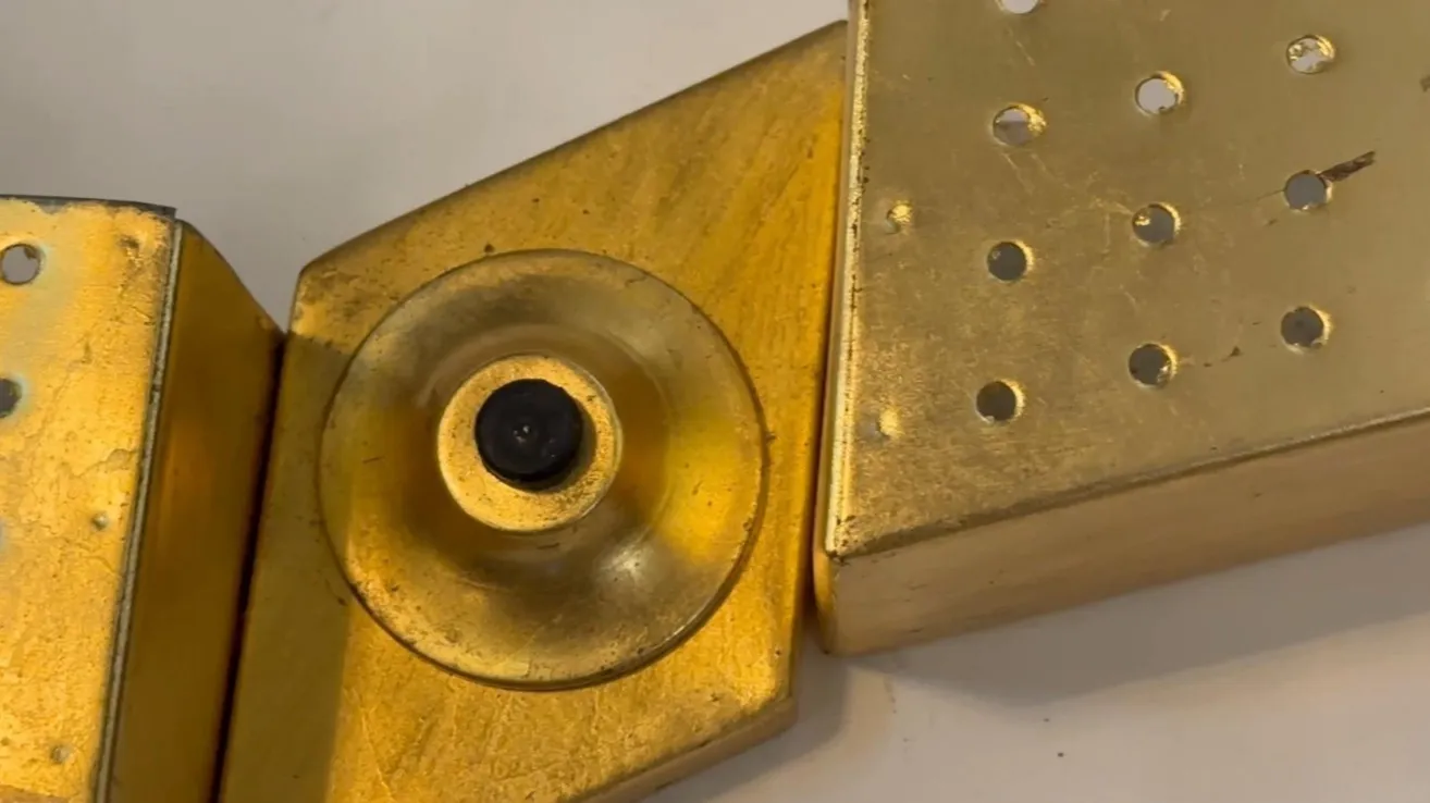 Antique sconce with golden design and visible details on a light background.