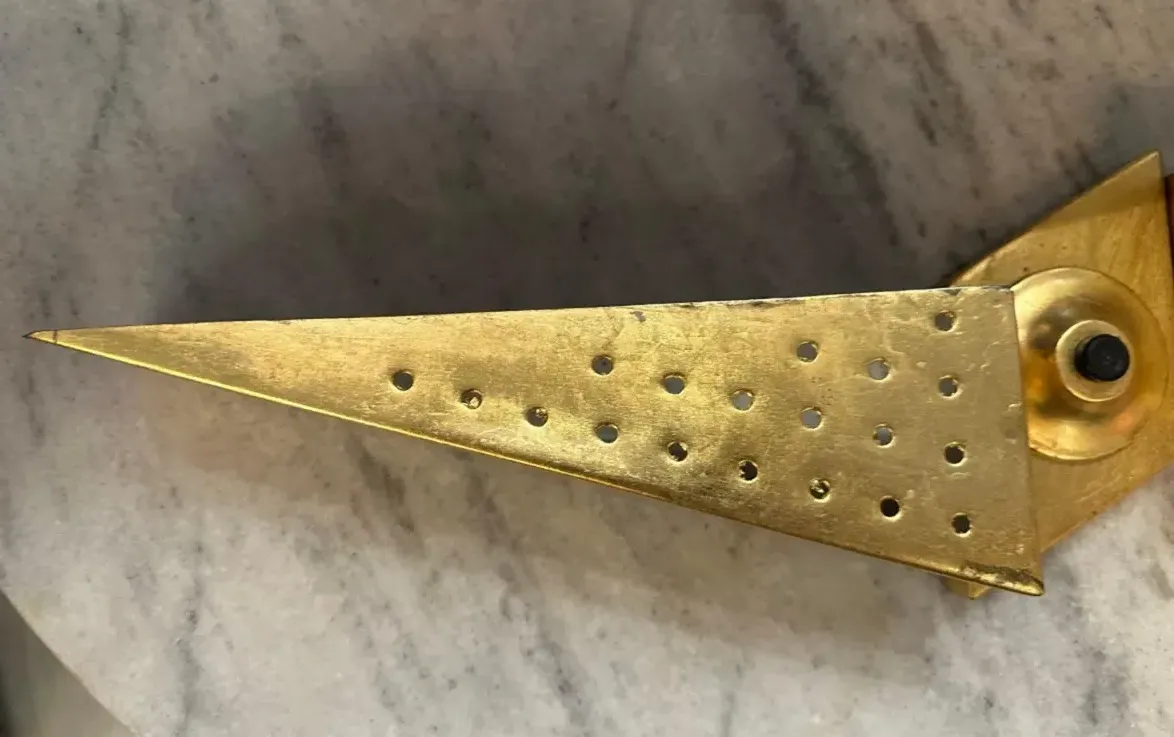 Apparecchio da parete antico con design perforato, atmosfera accogliente.