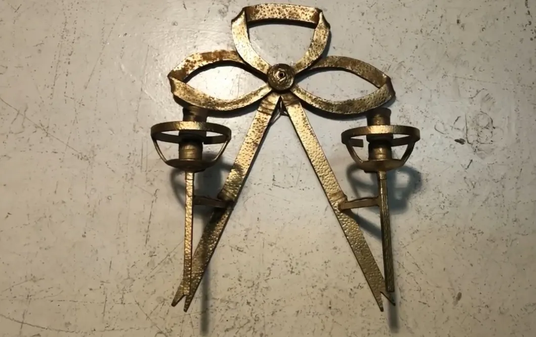 Par de apliques antiguos con un diseño en forma de lazo, ideal para ambientes elegantes.