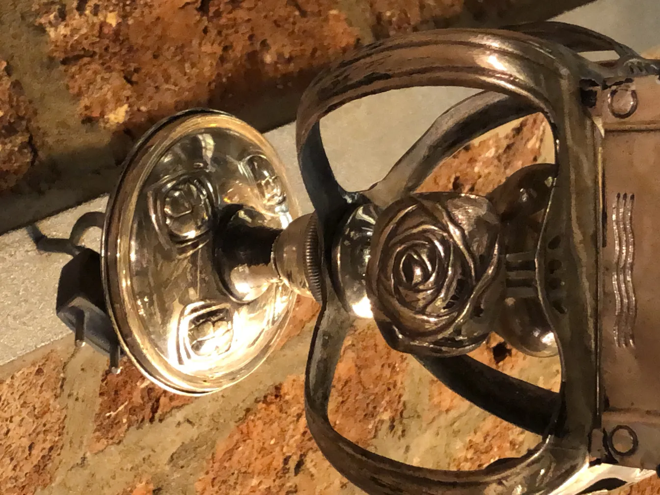 Antike Lampe mit Rosendetails und Backsteinwand