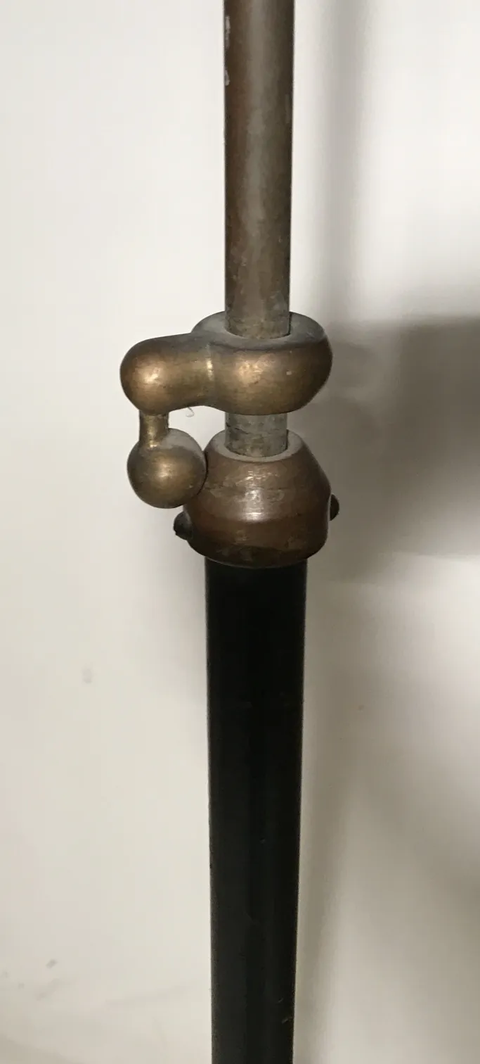 Une lampe sur pied ancienne dans un cadre chaleureux, avec une ornementation simple.