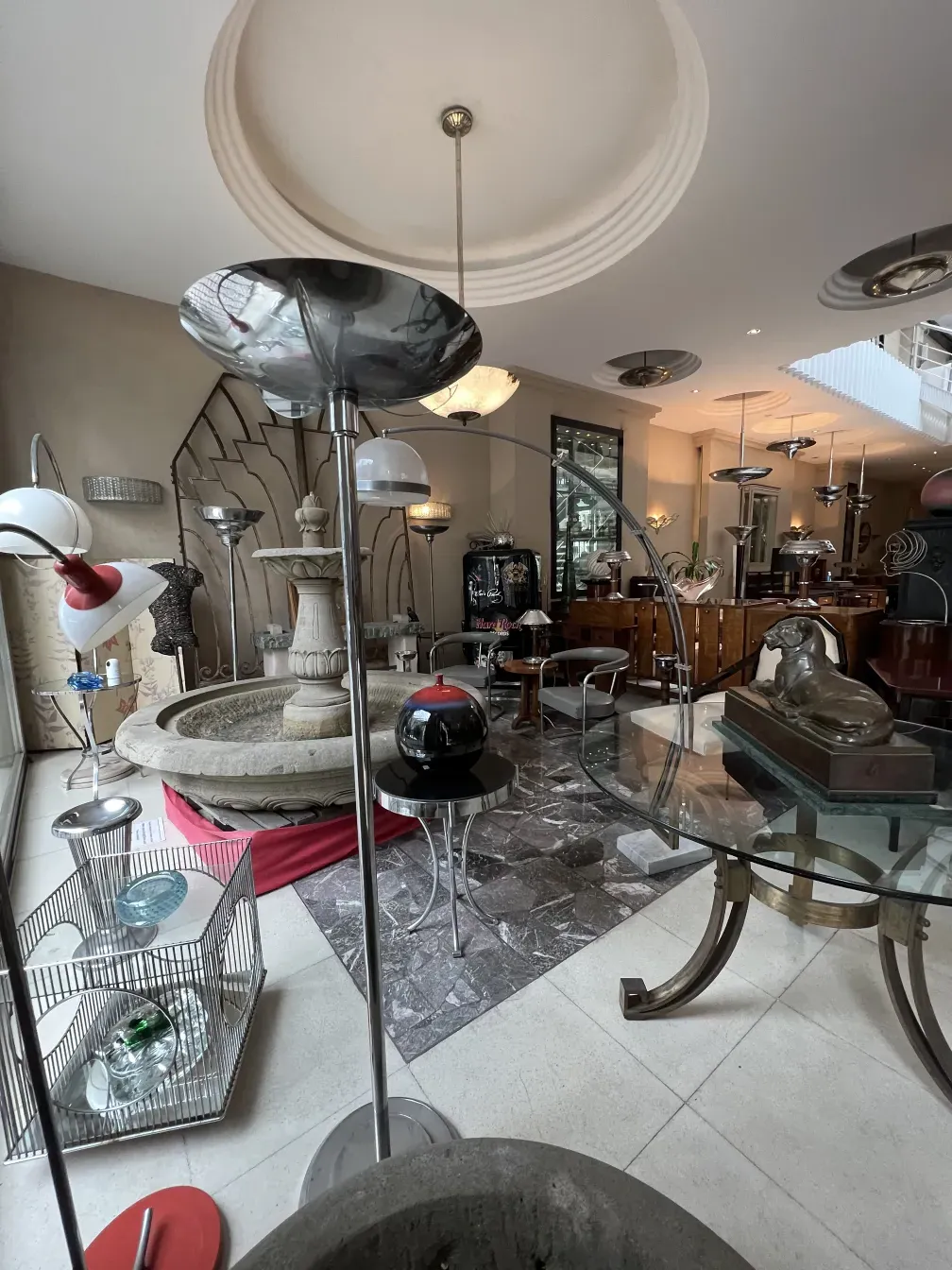 Lámpara de pie antigua estilo Art Deco en un entorno elegante con muebles variados.