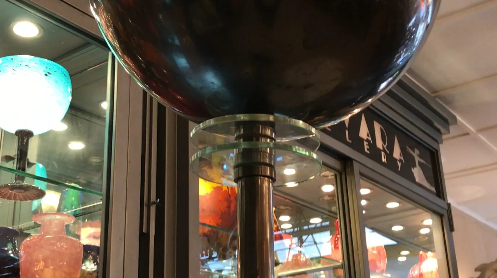 Lampada da terra antica con design Art Deco, dettagliata ed elegante, in un ambiente di esposizione di antiquariato.