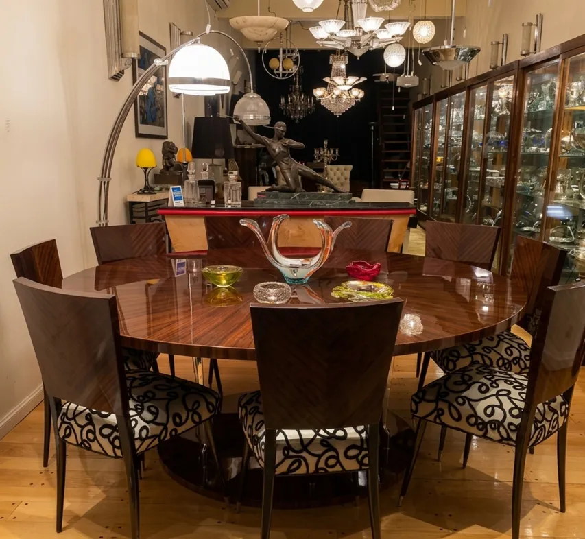 Uma luminária de pé antiga Art Deco iluminando uma mesa redonda.