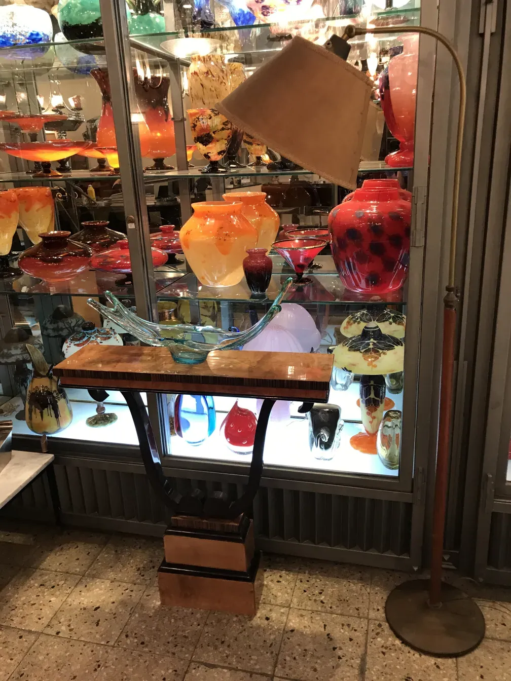 고전적인 플로어 램프가 다채로운 장식품들 사이에 놓여 있습니다.