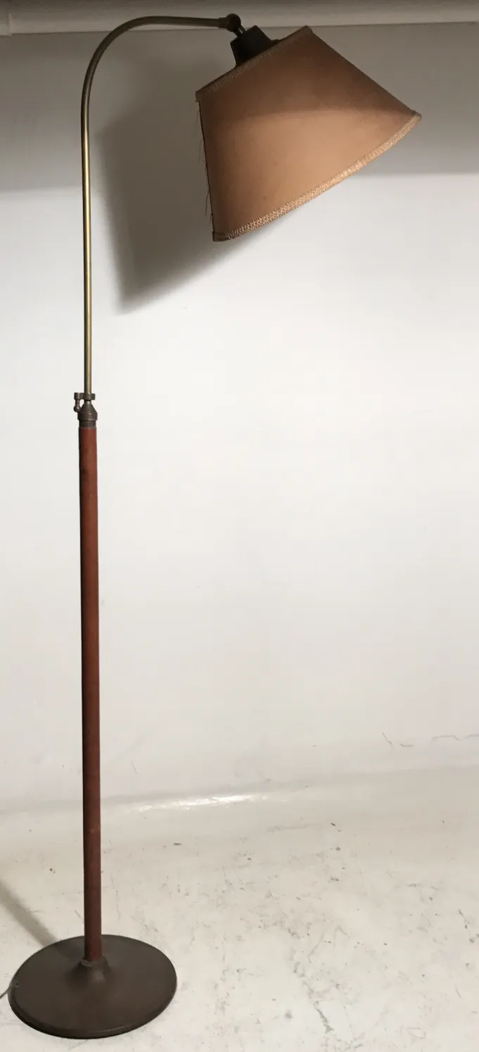 Antique floor lamp with brown shade in a neutral setting.