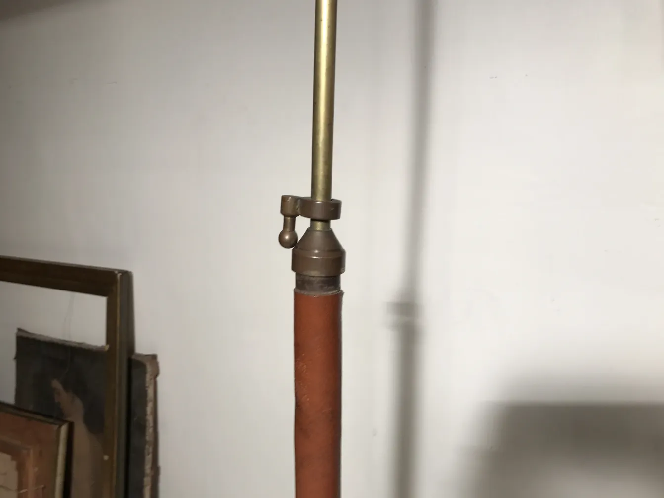 Antique floor lamp in art deco style with bronze and leather details in a cozy setting.