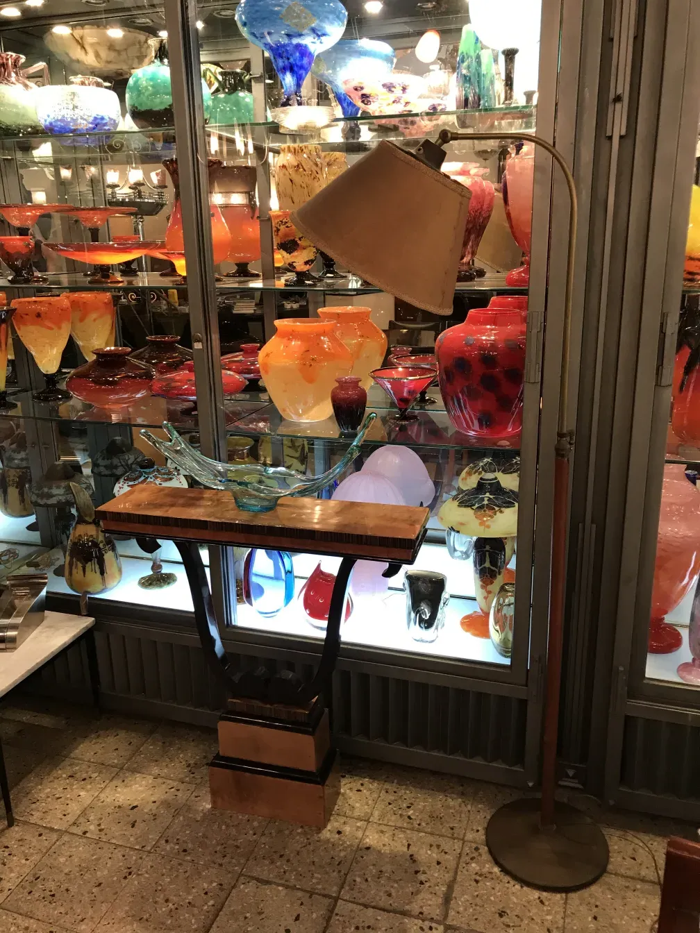 Antike Stehlampe vor bunter Glasvitrine