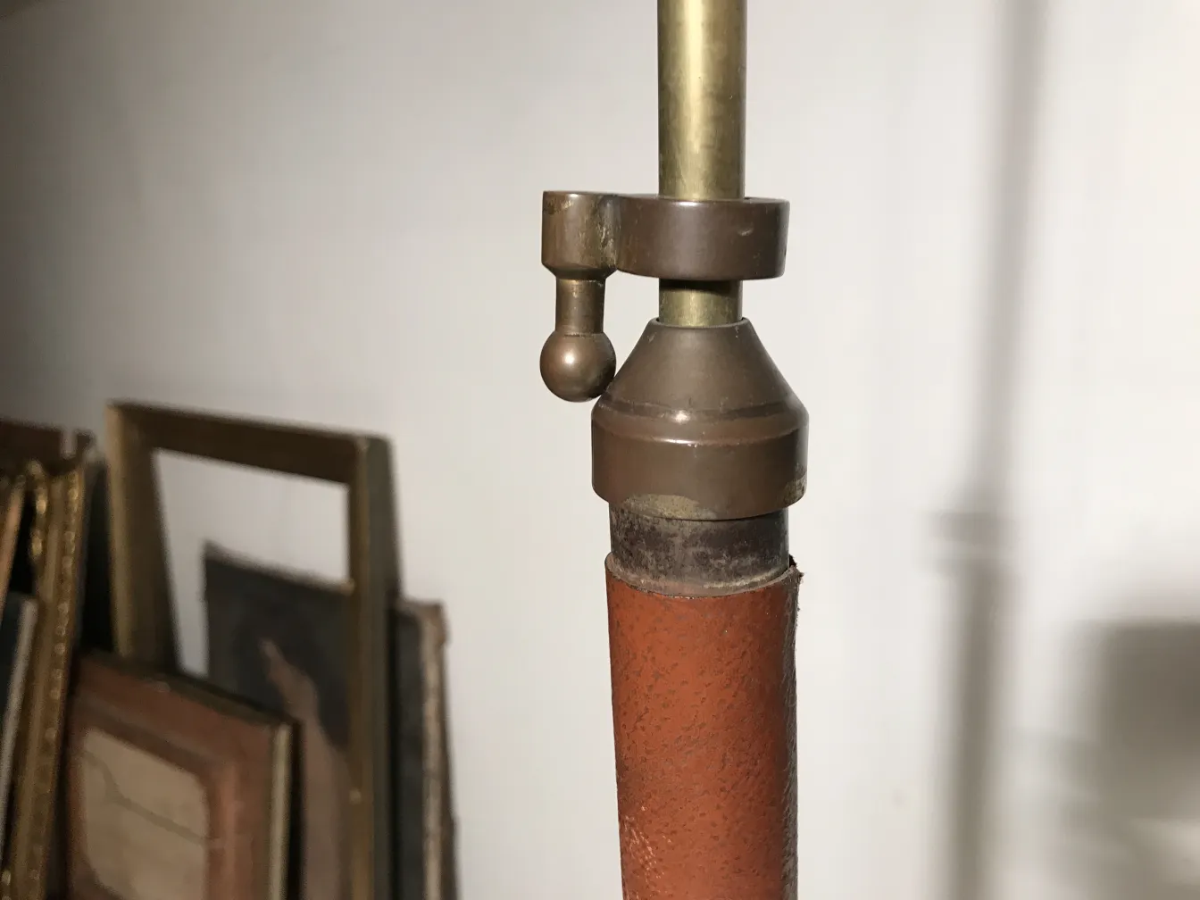 Antike Stehleuchte Art Deco mit Metalldetails, Hintergrund mit gerahmten Bildern