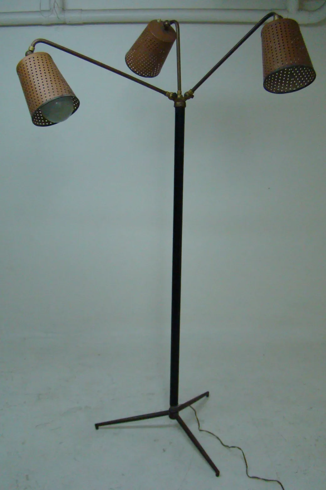 Luminária de pé antiga com cúpula perfurada e base estável.