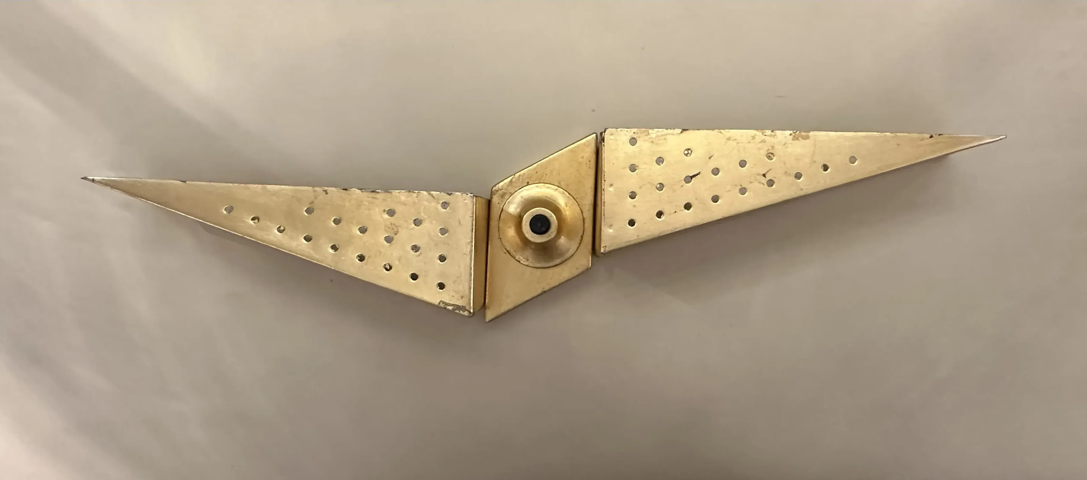 antiguo aplique de pared con forma angular y detalles perforados