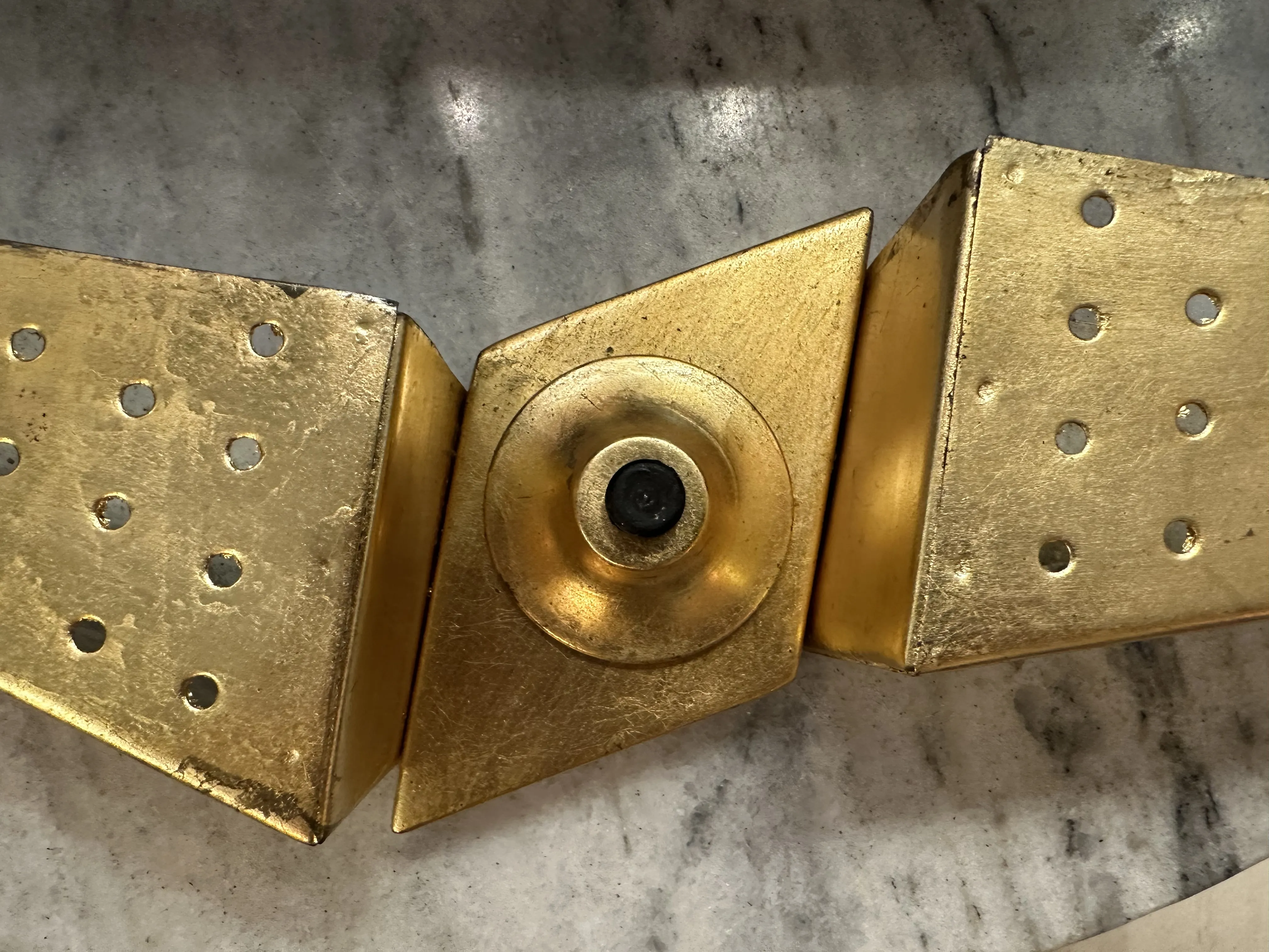 Apparecchio da parete antico con design geometrico e finitura dorata, perfetto per l'arredamento.