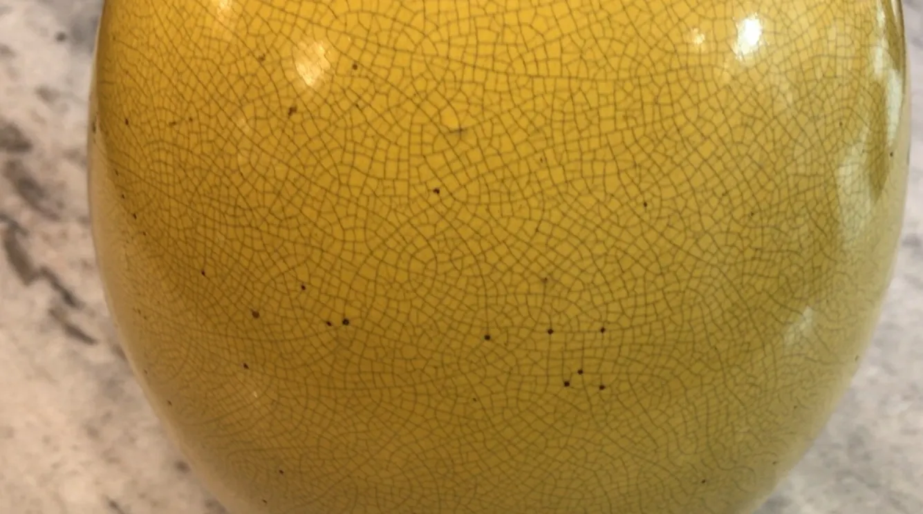 detalhe de uma luminária de mesa antiga art deco amarela com textura