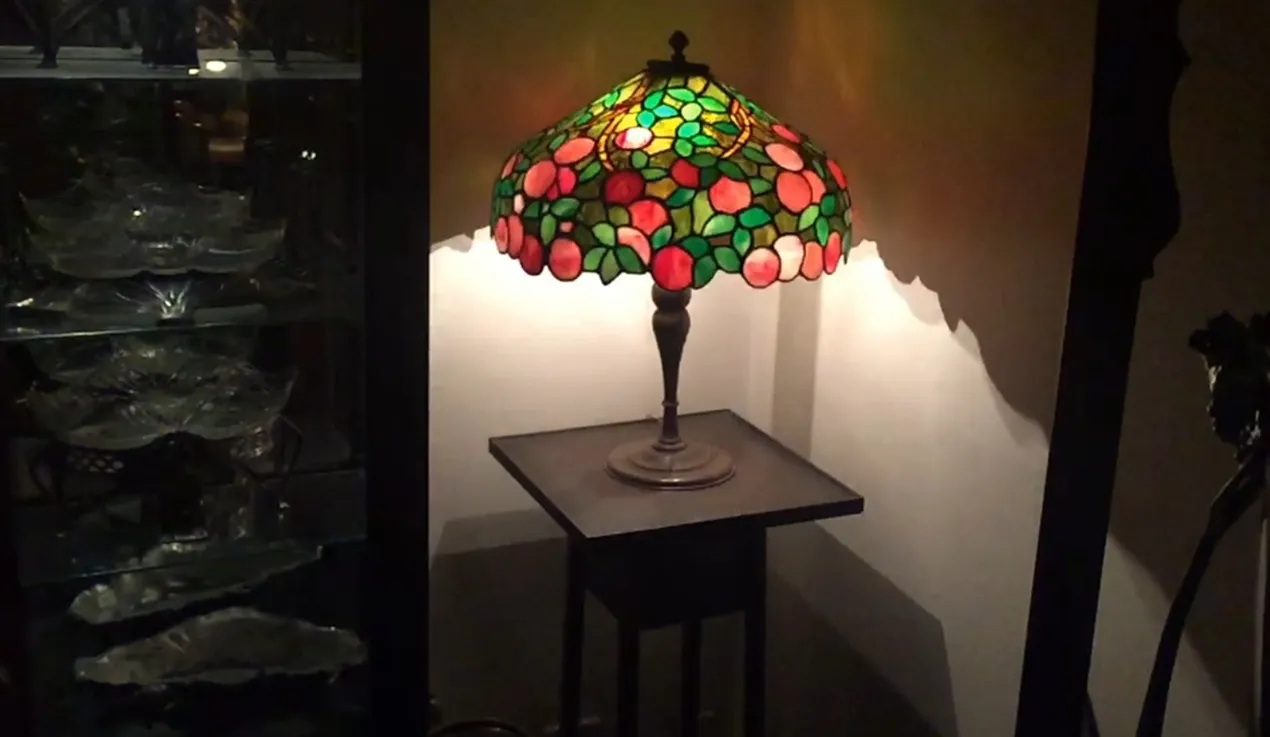 Lampe de bureau antique avec un abat-jour coloré et un design art déco.